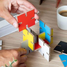 Colorful puzzle pieces being assembled on a wooden surface with a cup of coffee in the background.